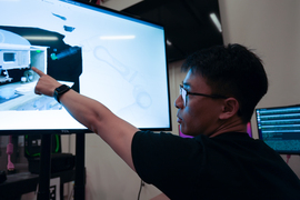 Felix Yanwei Wang working with a robot’s interactive system on a large screen