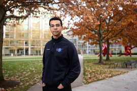 Josh Randolph stands in an MIT courtyard on an autumn day.
