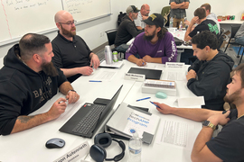 Two tables are filled with students in conversation.