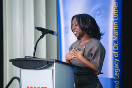 Ekua Beneman speaks at a lectern