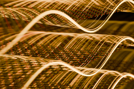 Tiny array of spheres sway up and down on wavy light.