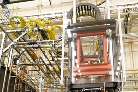 The large device, with a huge metal tub, is surrounded by pipes and gadgets.