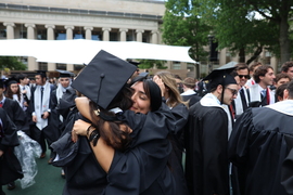 Two graduates hug