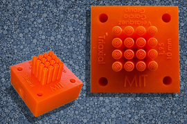 An aerial and side view of a 3D printed square with an array of nozzles in center.
