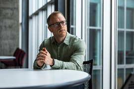 Brian Hedden seated at an indoor table near French doors