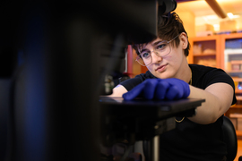 Closeup view of Shannon Knight placing a slide under a microscope