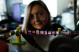 A 12-inch sized tube glows blue and white, with McKinney blurry in background.