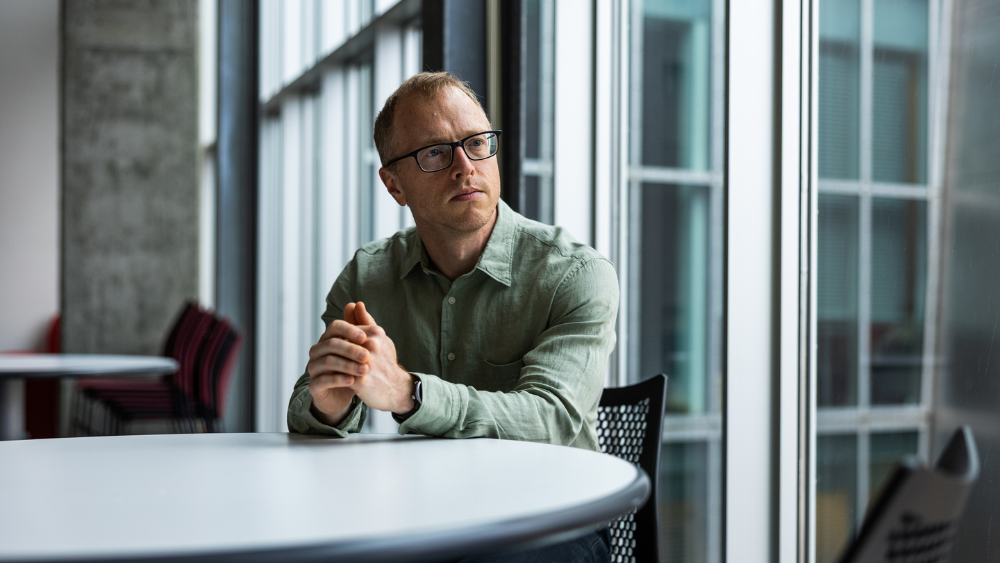 Brian Hedden seated at an indoor table near French doors