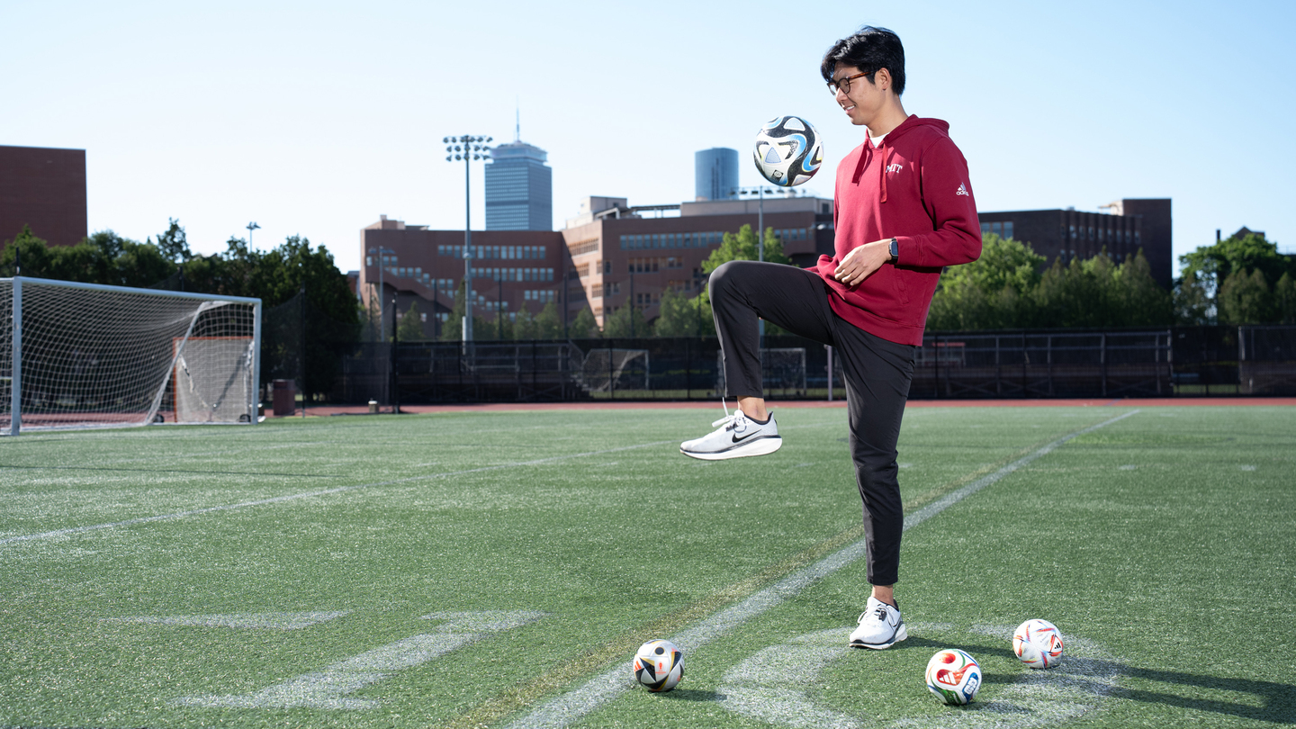 Henry Wang knees a soccer ball on the field.