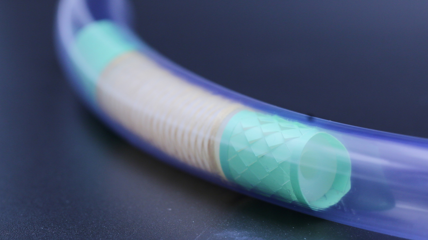 Closeup photo of a tiny, long tube with teal material inside.