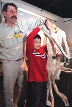 Ryan Pradit, 9, of Portsmouth, NH, holds the internal part of an actual NASA spacesuit while Donald W. Rethke ("Dr. Flush") explains how the tube-filled suit works to keep an astronant both warm and cool at the same time.