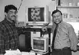 Dr. Jitendra Sharma (left) and Professor Mriganka Sur, head of the Department of Brain and Cognitive Sciences, stand next to laboratory monitors showing data on brain activity.