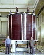 The inner module of a superconducting magnet built by the US team (left photo), with magnet team members including Rui Vieira of MIT (far left); and the outer module built by the Japanese team (right photo).
