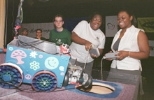 Jasmine Richards (right) helps Kiwah Kendrick (left) operate her decorative "Lady K" vehicle while Micah Smith, a graduate student and judge, looks on during the annual Design 2.007 robot contest.