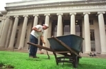 John Devlin of Faciltiies' grounds crew uncovers the built-in supports for the stage that's about to be installed for Commencement.