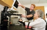 Dan Doherty, a physical therapist at Spaulding Rehabilitation Hospital, helps a patient work with MIT-Manus during her rehabilitation therapy following a stroke.