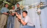 MIT researchers in the Department of Aeronautics and Astronautics stand with the instrumented truss that is key to the first hands-on experiment aboard the International Space Station. Left to right: sophomore Cemocan Yesil, Associate Professor David Miller, postdoctoral fellow Gregory Mallory and graduate student Jeremy Yung.