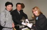 Jamie Hsu (center), executive director of technology management and technology intelligence for General Motors, presented two historic lead-salt diode lasers to the MIT Museum's Science and Technology Collection. Elizabeth Lo (left), wife of the late GM scientist Wayne Lo who developed these lasers, looks on as Jane Pickering (right), director of the MIT Museum, takes a close look at the tiny lase...