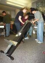 Students in 2.009 came up with some useful inventions, including Laddy, a ladder/dolly/motorized tool lift. Putting the finishing touches on Laddy are Heather Marshall (left), Elizabeth Ellingson (crouching) and Kathee Lee, all seniors in mechanical engineering.