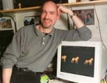 Associate Professor Earl K. Miller with computer monitor images of morphing dogs and cats that monkeys are able to categorize.