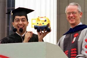 Soulaymane Kachani, president of the Graduate Student Council, presents President Charles M. Vest with a replica of the SafeRide bus that the graduate students are donating to MIT.