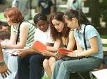 Left to right: Christine Fry, Shantel Poulson, Swati Saini and Tianlun Yu refer to the "Hitchhiker's Guide to Orientation 2001" while waiting for lunch in Killian Court.