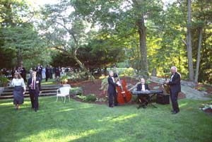 Guests stroll and musicians play during the retirement party at Endicott House.