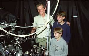 Professor Ketterle shows his atom laser apparatus to sons Jonas, 15, and Holger, 9.