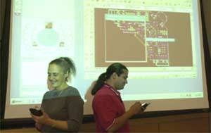 Team leaders Janice Klein and Feniosky Peï¿½a-Mora demonstrate use of personal digital assistants that will be key to a system for streamlining communications for virtual business meetings.