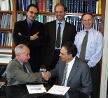Professor Lionel Kimerling (seated, left) and Pirelli Labs Optical Innovation Vice President Giorgio Grasso (right) shake hands at a gathering with (left to right) Massimo Gentili, head of nanotechnology, Pirelli Labs Advanced R&amp;D; Marco Romagnoli, head of optical devices, Pirelli Labs Advanced Photonics Research; and George Kenney, associate director of the MIT Microphotonics Center, at the s...