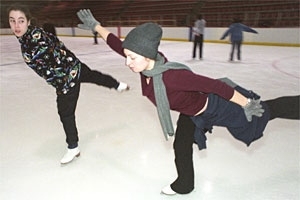 Alexandra Dunne-Bryant, Wellesley '02, rear, gives some tips to Yana Averbukh, MIT '05, as they practice spirals during an IAP figure skating class.