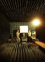 At Lincoln Lab's Advanced Electromagnetic Systems Antenna Test Range,        Alan Rogers (right) associate director and senior research scientist at        Haystack, works with scientist Kevin Kolodziejski of TruePosition Inc. in        a special chamber that dampens the echo of radio signals. They are testing a prototype cell phone antenna that measures the angle of arrival of the phone's signal,...