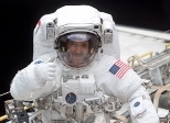 John Grunsfeld gives a thumbs up during an Extravehicular Activity, the 25th by  an MIT graduate.