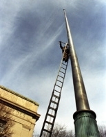 John Coyne mounts sensor boxes atop the flagpole in Dupont Court to monitor the motion of the flagpole in the wind for the iCampus Flagpole Instrumentation project in civil and environmental engineering.