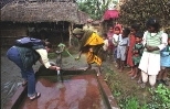MIT student Hannah Sullivan takes a water sample from a well in the village of Mahilwari, Nepal, assisted by a villager. Hannah and seven colleagues visited villages in Nepal to test inexpensive ways to make drinking water safe.
