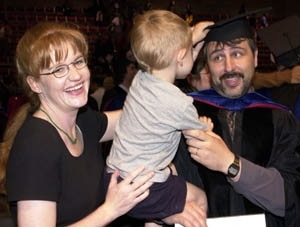 Yuri Ivanov gets his tassel turned (and hat swiped) by his three-year-old        son Sasha (held by his wife Sarah Wilkenson) just after receiving his Ph.D. in media arts and sciences.