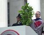 Senior class president Sudeb Dalai presents President Charles Vest with        a plant that a friend of his "borrowed" from Vest's office four years ago after hacking his way in.