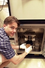 Graduate student John Kisiday removes a sample of engineered cartilage that was created using a novel "designer gel" from a machine that encourages cell and matrix growth.