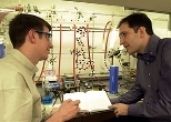 Graduate student Michael C. Hewitt, left, speaks with Professor Peter H.        Seeberger in the lab where their work on malaria has been taking place.