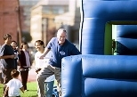 President Charles Vest makes it through the first leg of the obstacle-course relay race as he rushes the baton to his waiting teammates from the Presidential Seals.President Charles Vest makes it through the first leg of the obstacle-course relay race as he rushes the baton to his waiting teammates from the Presidential Seals.