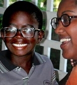 Senior Selam Daniel (right) of chemical engineering smiles after fitting a very nearsighted Guyanese boy with eyeglasses, his first pair ever.