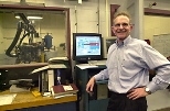 Professor John B. Heywood relaxes in the Sloan Automotive Laboratory, which includes a test cell (background) containing a 2002 Cummins ISB300 diesel engine used in Dodge pickup trucks.