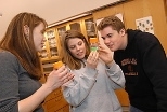 Postdoctoral associate Elizabeth Wiellette (left) engages Holliston High students Kristina Bachrach and Bradley Reed during their school's trip to MIT.
