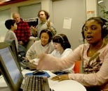 Professor Tod Machover, rear, gestures to one of the Toy Symphony composers, Joshua McLellan, and his dad, Vincent, as MIT UROP student Kay Tye works with composer Kattie Dwyer, 11, of Chelsea. At right, Teyanna Powell-Hughes of Dorchester composes music with a flourish.