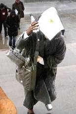 Unidentified woman tries to shield herself from the elements as she approaches the main entrance to MIT.