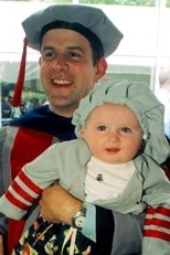 Six-month-old Miles Fox-Kempler, all dressed up in toddler-sized MIT regalia, relaxes in his father's arms at the doctoral hooding ceremony. Baylor Fox-Kemper received the Ph.D. in physical oceanography.