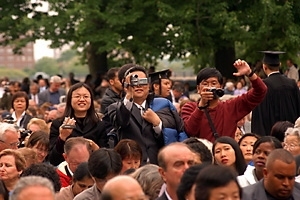 Sloan School Ph.D. Peng Sun's guests record his big moment for the family archives. They are (from left) his wife, Huina Chen; his father, Yongqi Sun, who traveled to Commencement from Tianjin, China; and a friend, Melvin Sim.