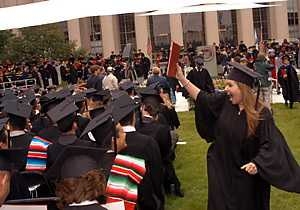Nancy Ramirez waves her mechanical engineering degree triumphantly, much to the delight of the Ramirez family of Juana Diaz, Puerto Rico, and the audience on Killian Court.