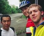MIT students and cross-country cyclists Taku Iida, Greg Mahowald and Kyle Rattray cross the Massachusetts-New York border.