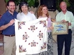 Organizers of the Crete workshop presented gifts to Shuguang Zhang, lead organizer of the conference, at a final banquet. Left to right: Michael Hecht, Zhang, Amalia Aggeli and Neville Boden display cloths bearing traditional Greek designs in patterns Hecht playfully called "self-assembled."